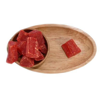 Close-up of vibrant orange dried papaya cubes neatly arranged in a wooden bowl.