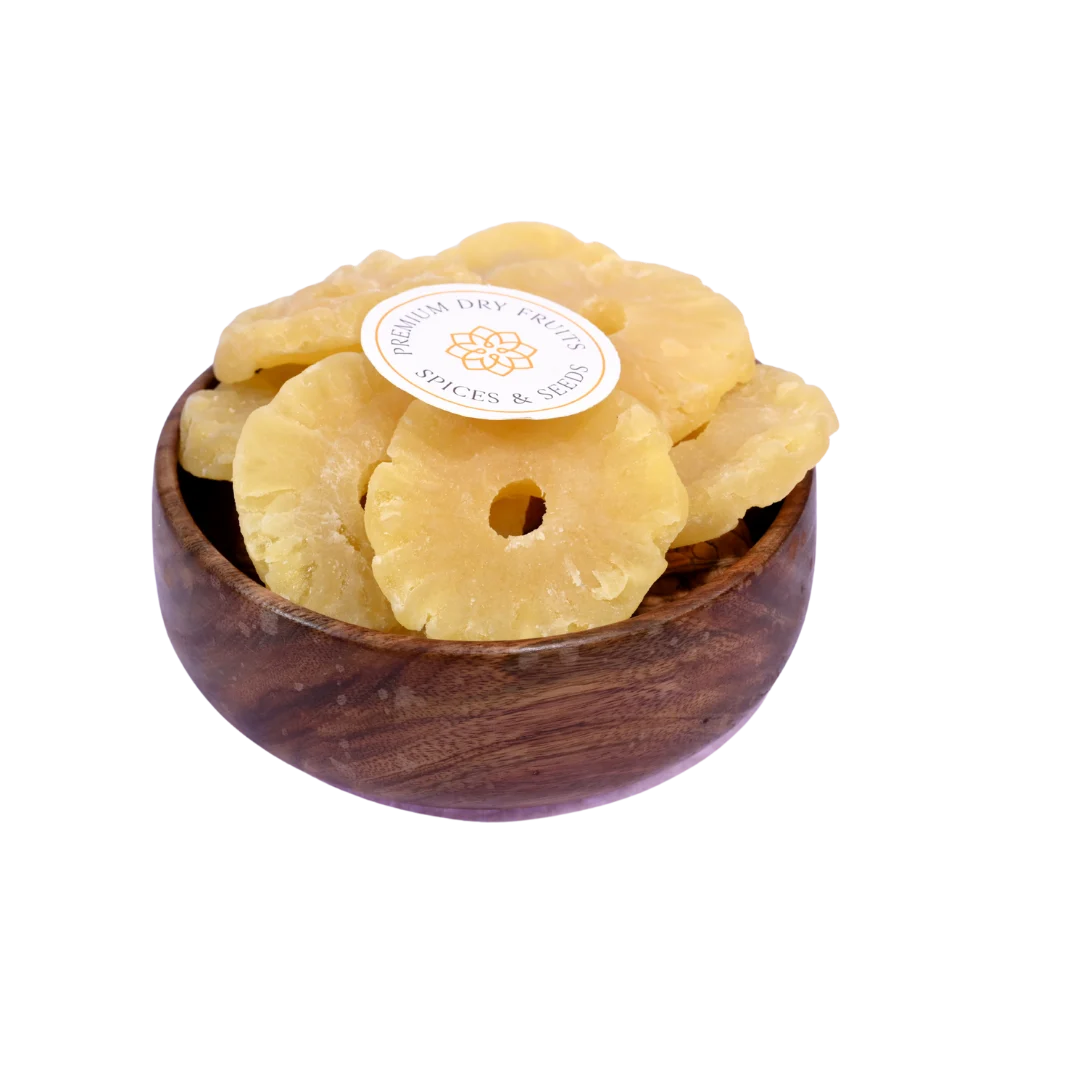 Dried pineapple slices in a wooden bowl on a white background
