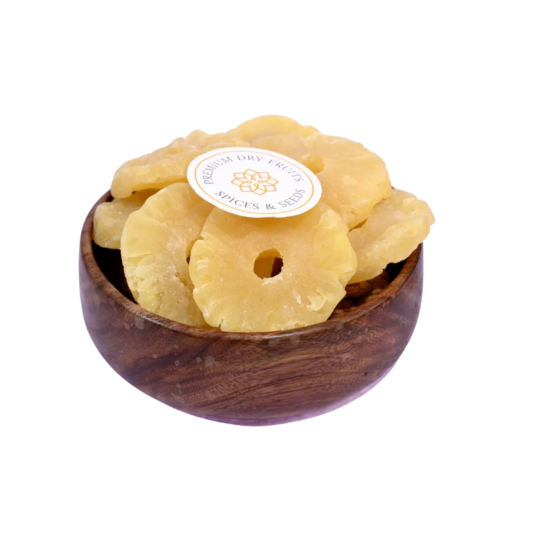 Dried pineapple slices in a wooden bowl on a white background