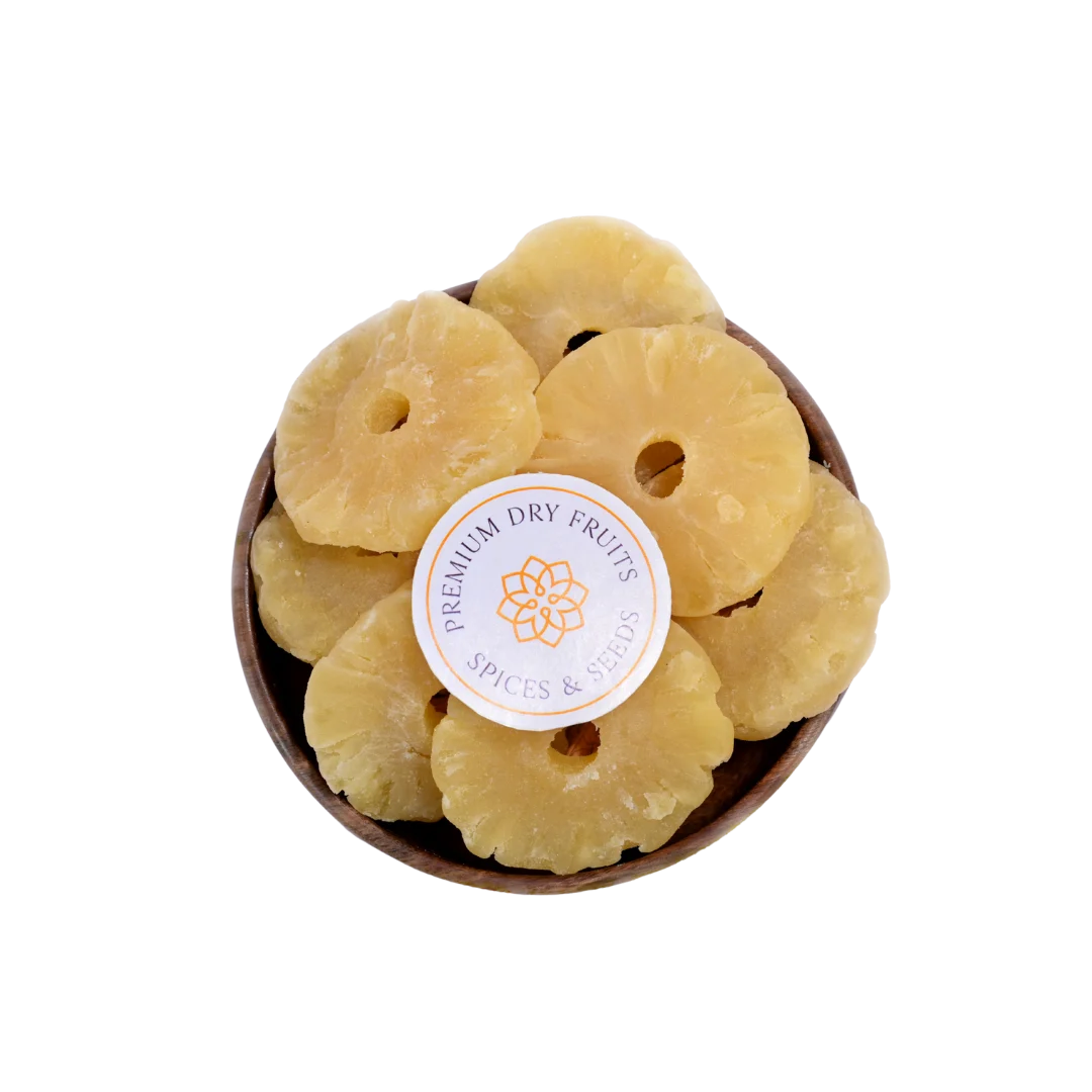 Dried Pineapple slices in a wooden bowl with a label on a white background