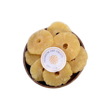Dried Pineapple slices in a wooden bowl with a label on a white background