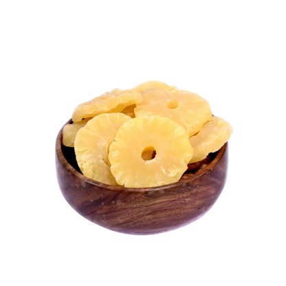 Dried pineapple slices in a wooden bowl on a white background