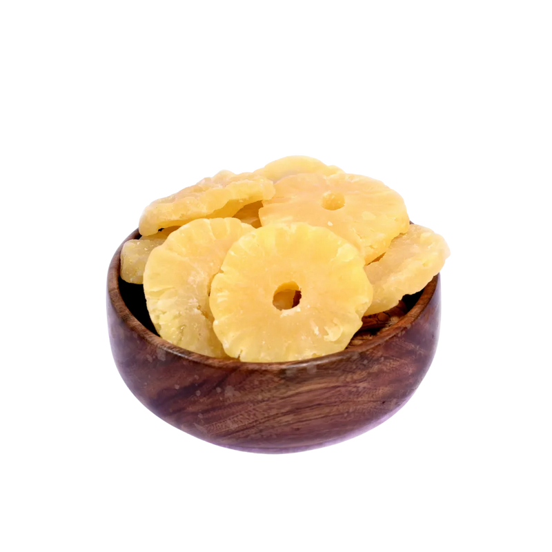Dried pineapple slices in a wooden bowl on a white background