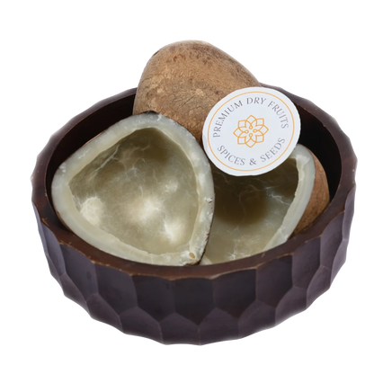 Natural Dry Coconut Halves / Copra displayed in a wooden bowl, showcasing their white flesh and brown shell.