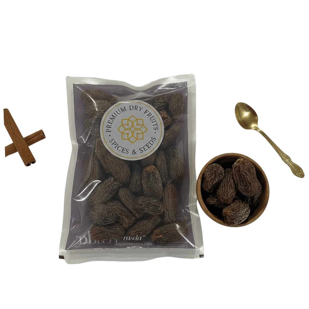Packaged Black Dry Dates with a bowl and spoon on a white background