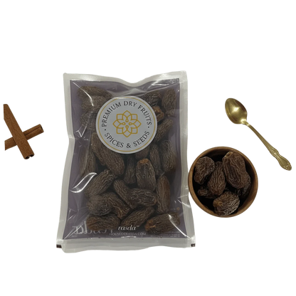 Packaged Black Dry Dates with a bowl and spoon on a white background