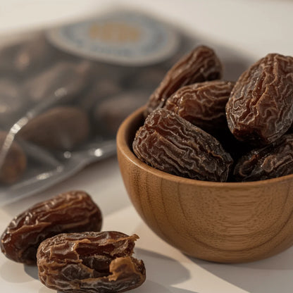 Black Dry Dates in a wooden bowl with a blurred background