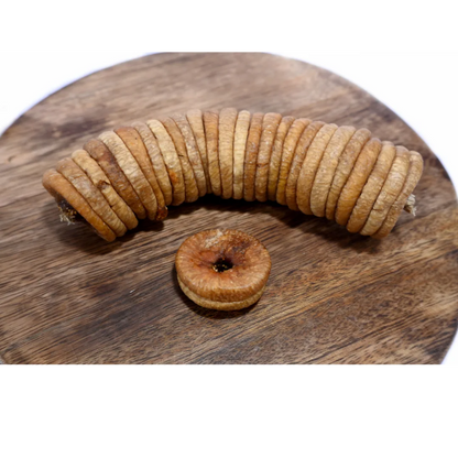 Dry Figs Choice Anjeer spread on a wooden surface, emphasizing their premium look and natural appeal.