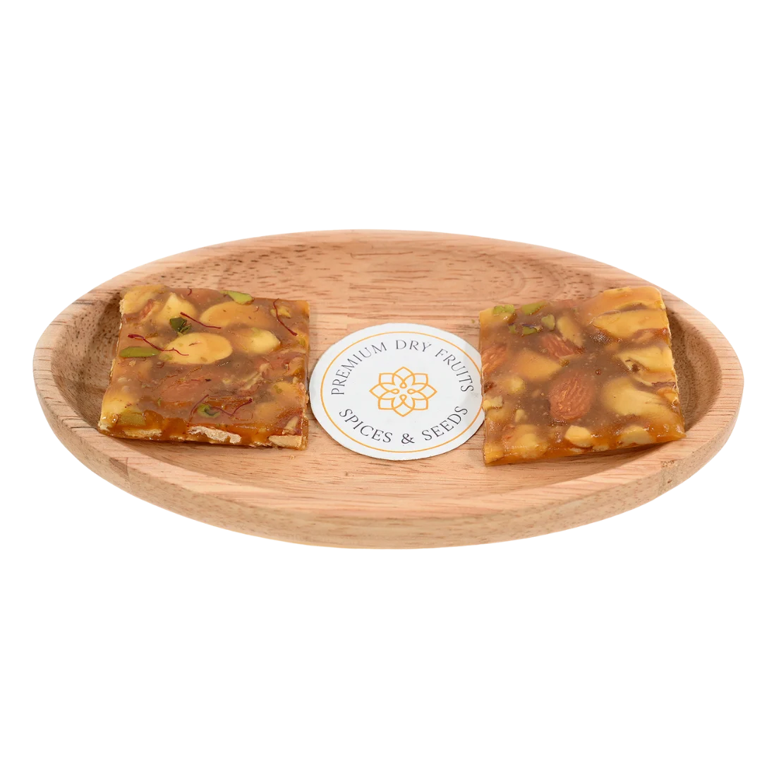 Dry Fruit Chikki on wooden plate delicious Indian brittle made with roasted nuts and jaggery perfect healthy snack for festive season and gifting