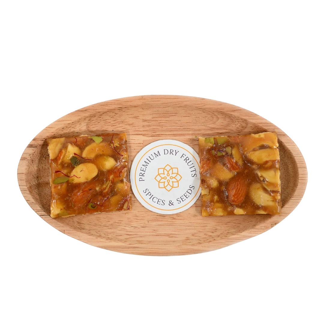 Dry Fruit Chikki on wooden plate crunchy jaggery bar with mixed dry fruits almonds and cashews nutritious Indian sweet ideal for winter and celebrations