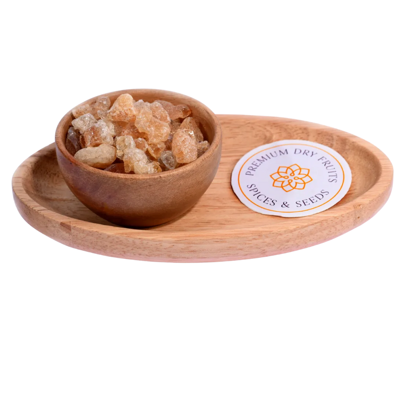 Gum / Gaundh in a wooden bowl showcases natural, crystal-like edible gum pieces.