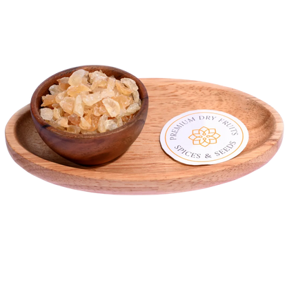 Gum Tragacanth or Gaundh Kateera in a wooden bowl showcases natural, translucent gum crystals.
