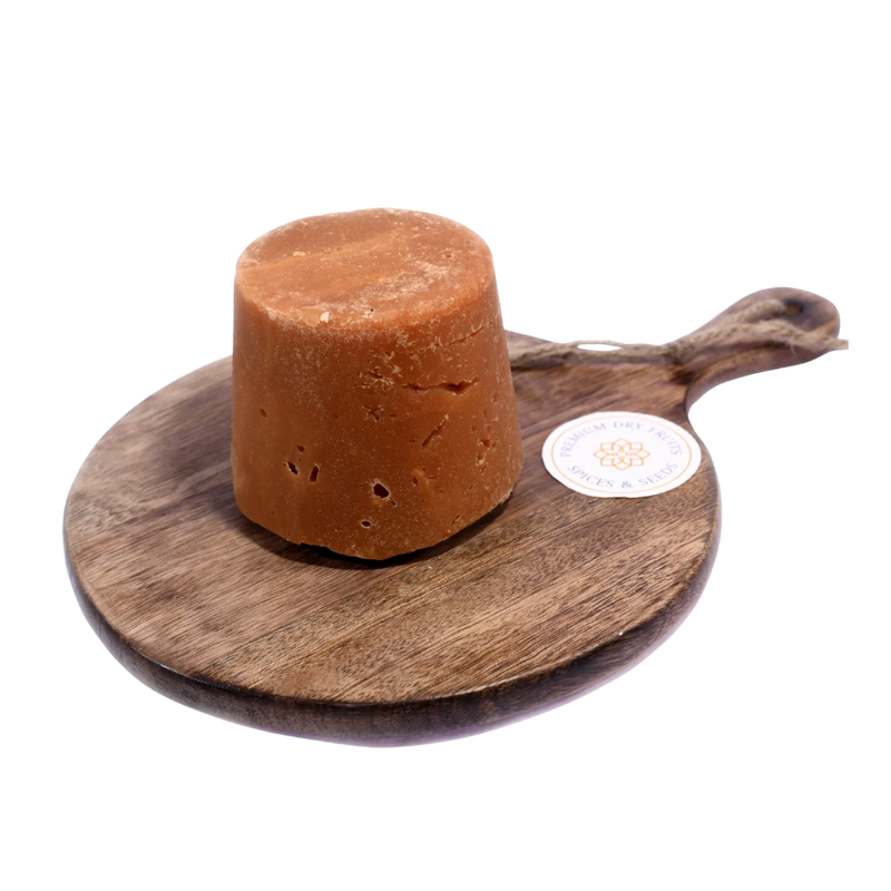 Golden brown Jaggery / Gud pieces in a wooden bowl, showcasing their natural texture and rich sweetness.