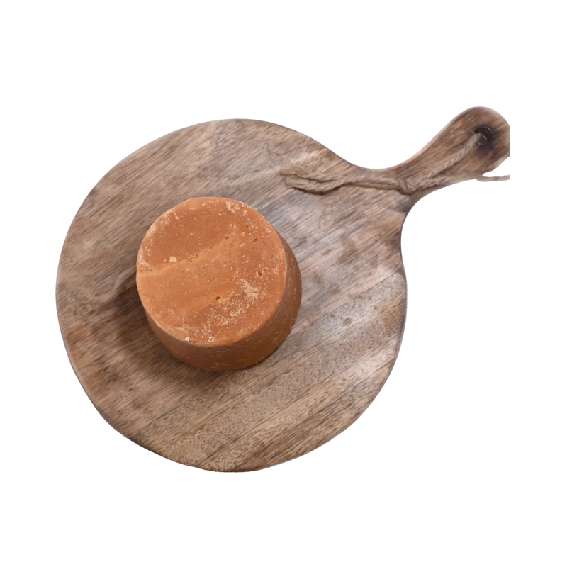Premium quality Jaggery / Gud cubes in a wooden bowl, showing their deep caramel color and natural purity.