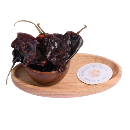 Kashmiri Chilli in a wooden bowl showcases vibrant red, mild, and aromatic spice flakes.