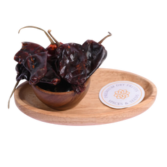 Kashmiri Chilli in a wooden bowl showcases vibrant red, mild, and aromatic spice flakes.