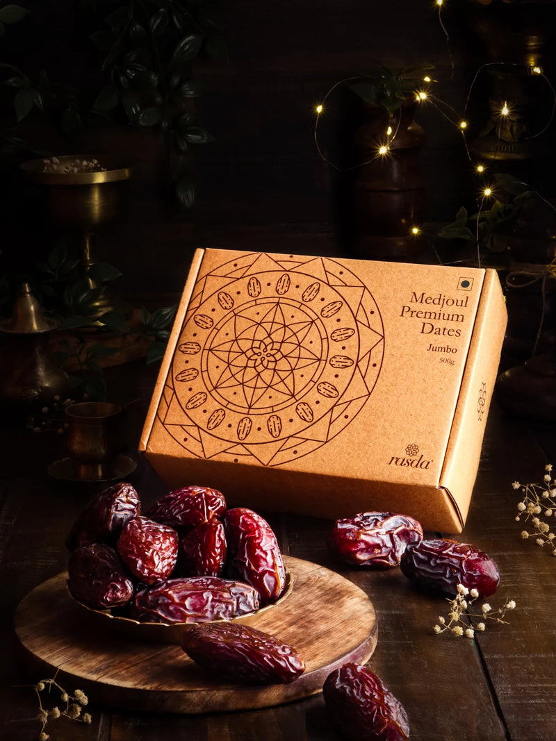 Box of Medjoul Premium Dates with dates on a wooden board against a dark background