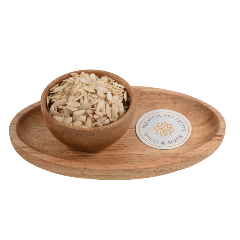 Premium muskmelon seeds (Kharbuja Magaj) in a smooth wooden bowl on a natural surface.