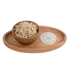 Premium muskmelon seeds (Kharbuja Magaj) in a smooth wooden bowl on a natural surface.