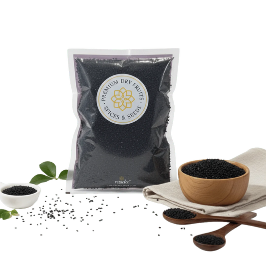 Bag of Nigella Seeds (Kalonji) surrounded by small bowls and a wooden spoon on a white background.