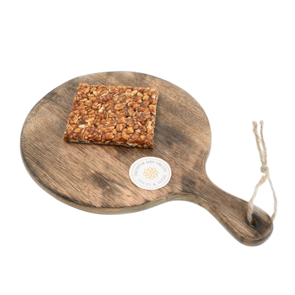 Peanut Chikki on wooden plate delicious Indian jaggery brittle loaded with peanuts tasty crunchy snack ideal for