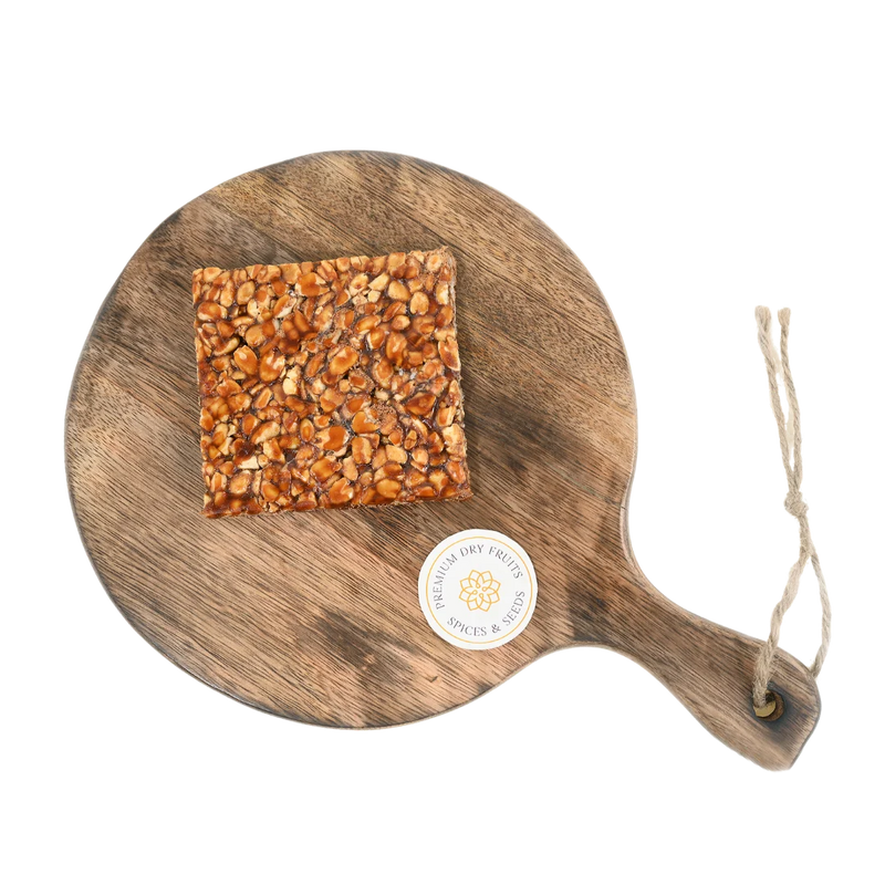 Peanut Chikki on wooden plate traditional Indian sweet made with roasted peanuts and jaggery healthy crunchy snack perfect for winter and festive season