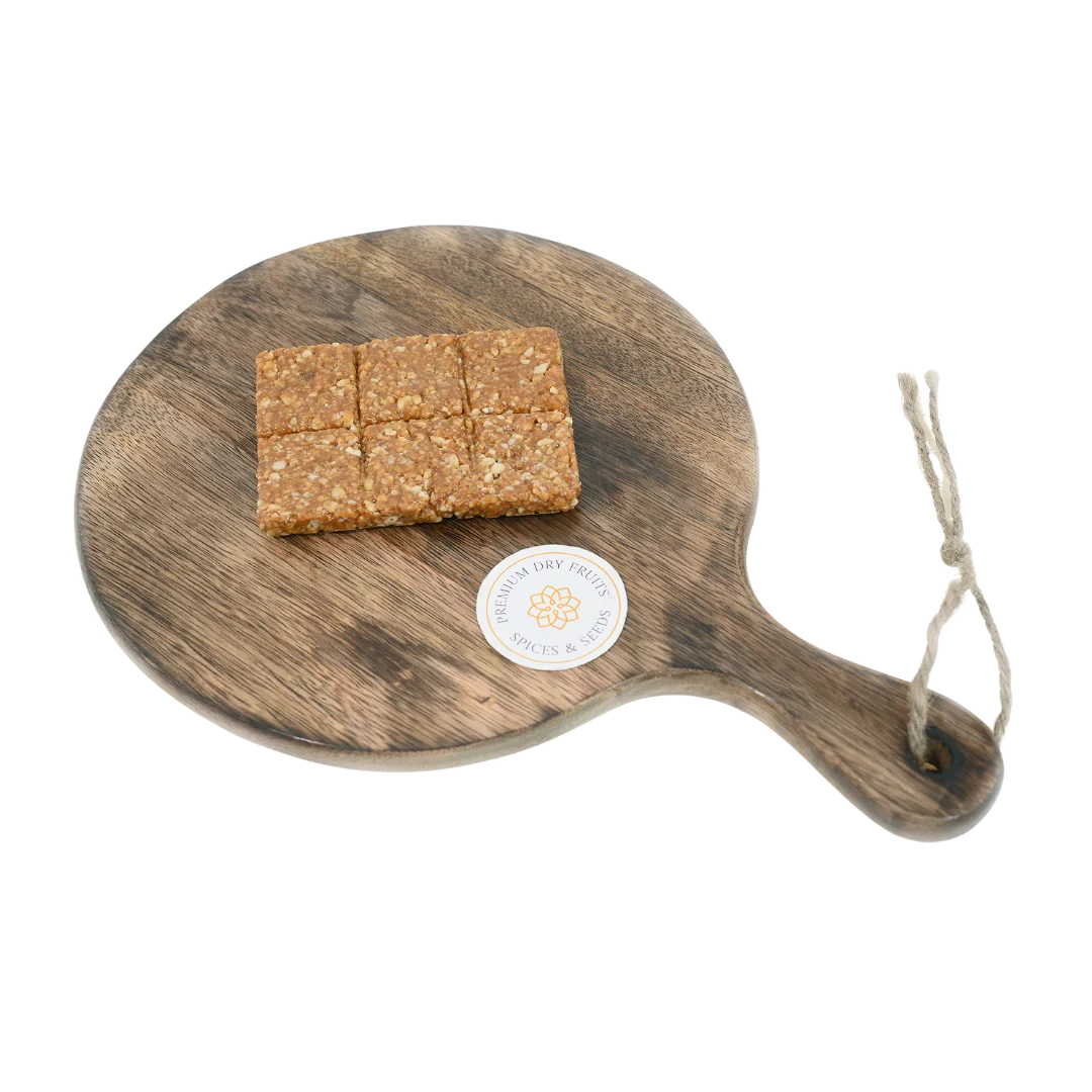 Peanut Crush Chikki on wooden plate traditional Indian sweet made with crushed peanuts and jaggery healthy crunchy