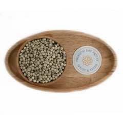 Wooden bowl filled with whole white pepper corns.