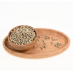 Close-up of white pepper corns in a wooden bowl