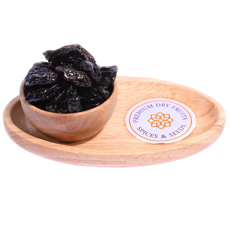 Pitted Prunes Dried in a wooden bowl showcasing their deep purple color and smooth, glossy surface.