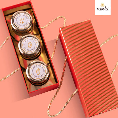 Three small jars in a red Rajastha sry fruits gift box with 'rasda' branding on a pink background.