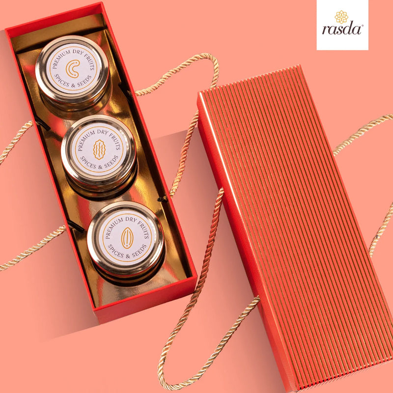 Three small jars in a red Rajastha sry fruits gift box with 'rasda' branding on a pink background.