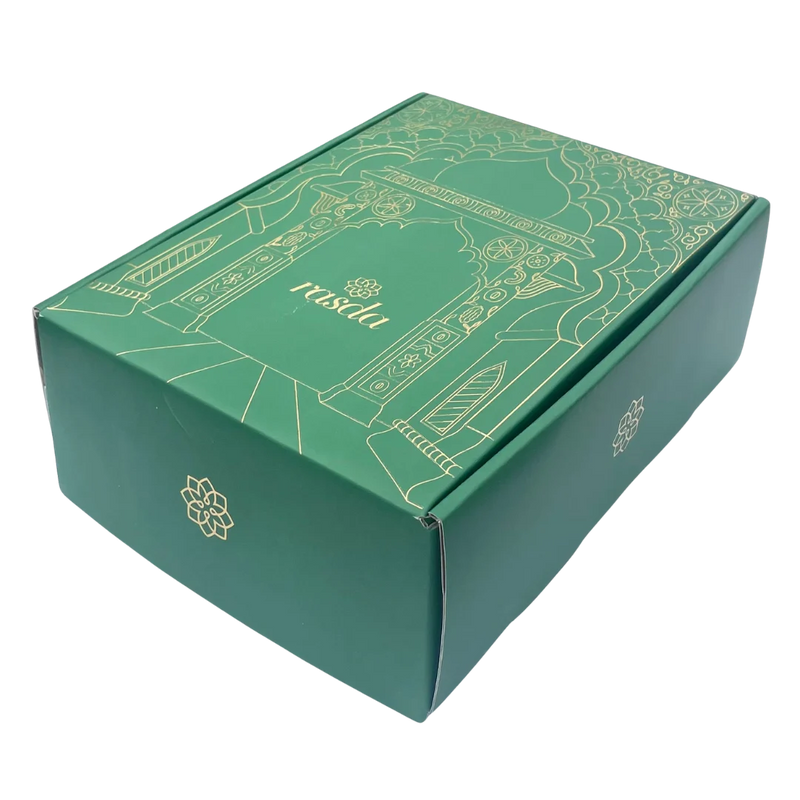 Premium Rashmika tin opened to reveal a colorful assortment of nuts and dry fruits, presented in a luxury gift box.