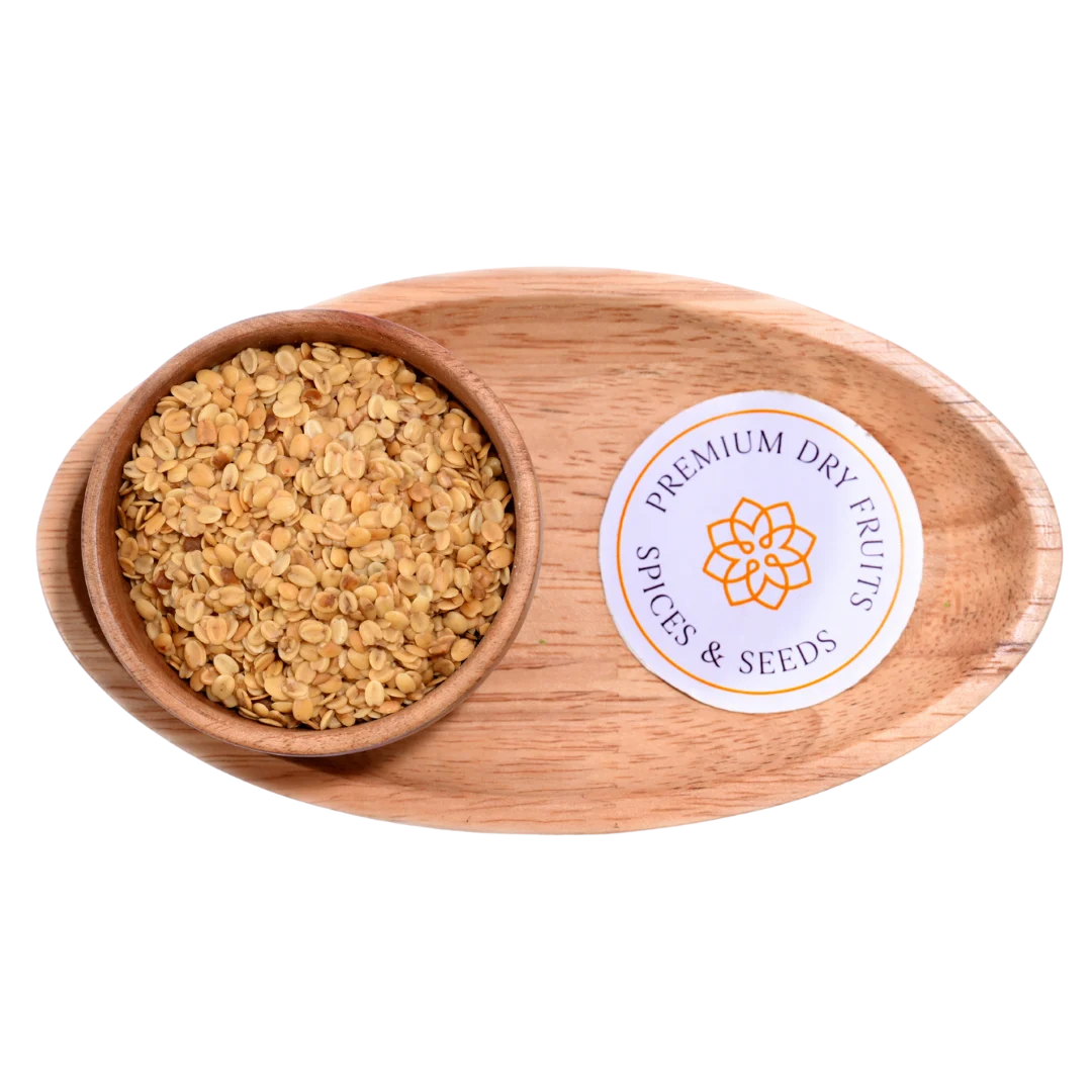 Premium Roasted Coriander Seeds or Dhana Dal displayed in a rustic wooden bowl, showcasing their golden roasted texture.