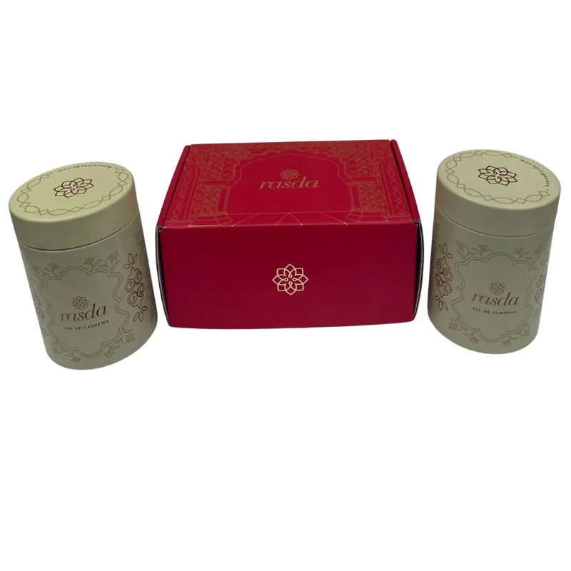 Two cylindrical containers with a red box in the center on a white background - Rudira Dry fruits Gift Box Premium with Tins inside.