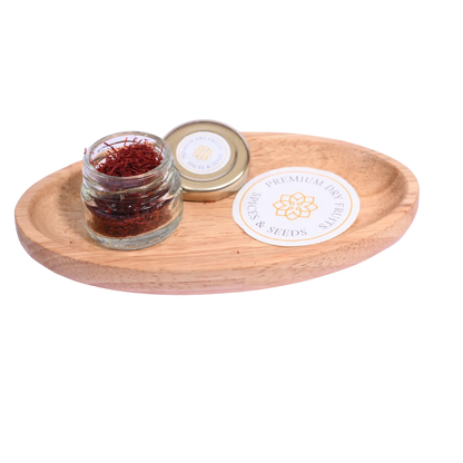 Jar of saffron on a wooden tray with a visible brand label on a white background