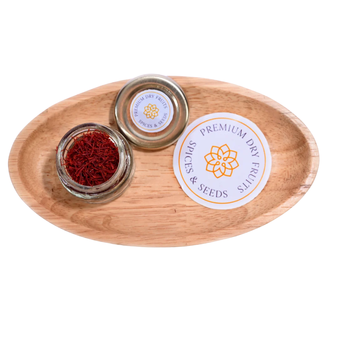 A glass jars with Saffron or Kesar on a wooden tray, featuring 'Premium Dry Fruits & Spices' branding.