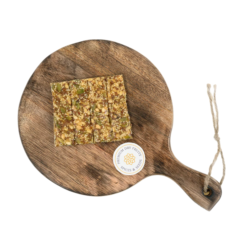 Seed Chikki on wooden plate delicious Indian jaggery brittle loaded with mixed seeds nutritious crunchy snack ideal for festivals and winter months