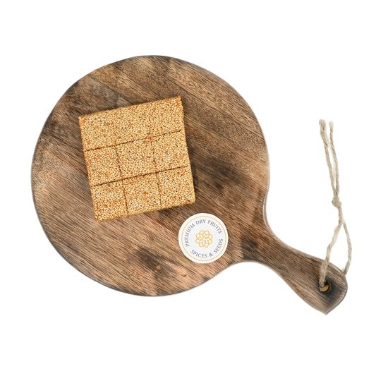 Sesame Chikki or Til Chikki on wooden plate traditional Indian sweet made with jaggery and roasted sesame seeds healthy crunchy snack winter special