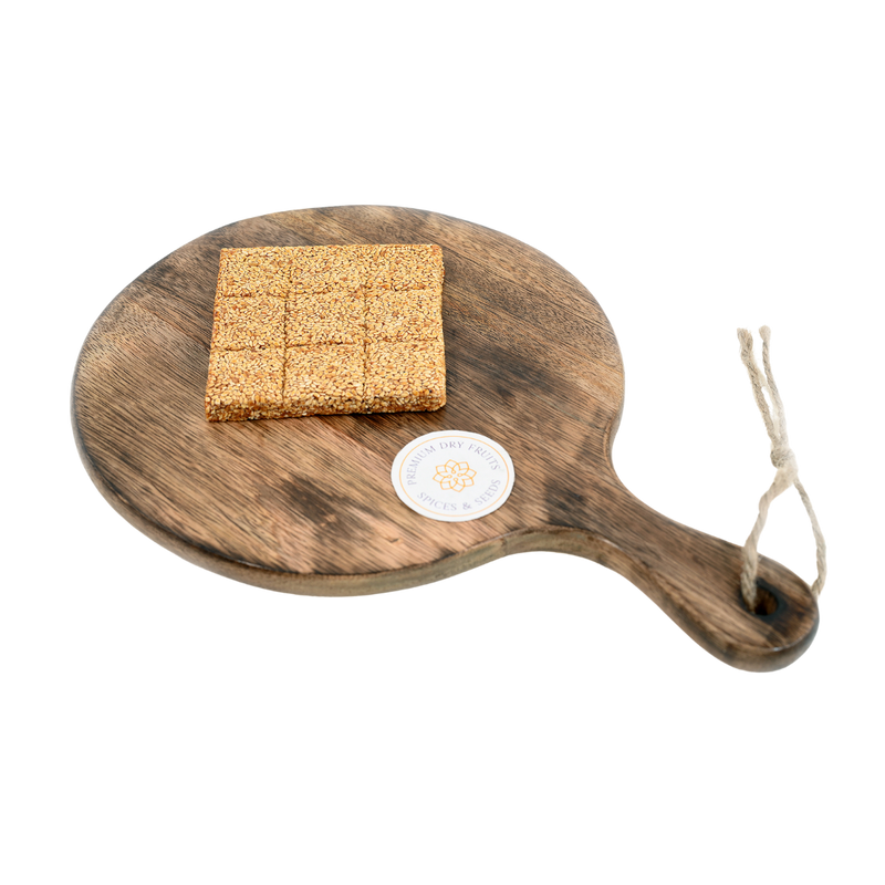 Close-up of til chikki squares – traditional Indian snack with golden sesame seeds and natural jaggery glaze.