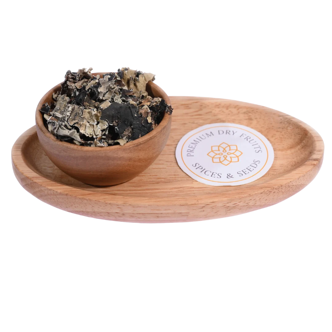 Stone Flower or Dagad Phool in a wooden bowl showcases dried, aromatic fungal spice pieces.