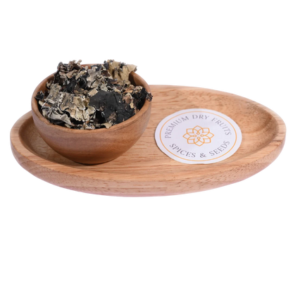 Stone Flower or Dagad Phool in a wooden bowl showcases dried, aromatic fungal spice pieces.