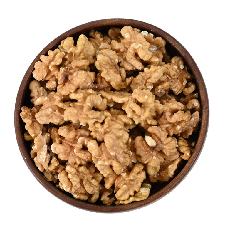 Wooden bowl filled with walnuts on a white background