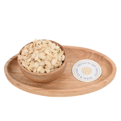 Close-up of watermelon seeds (Tarbuj Magaj) in a rustic wooden bowl on a wooden surface.