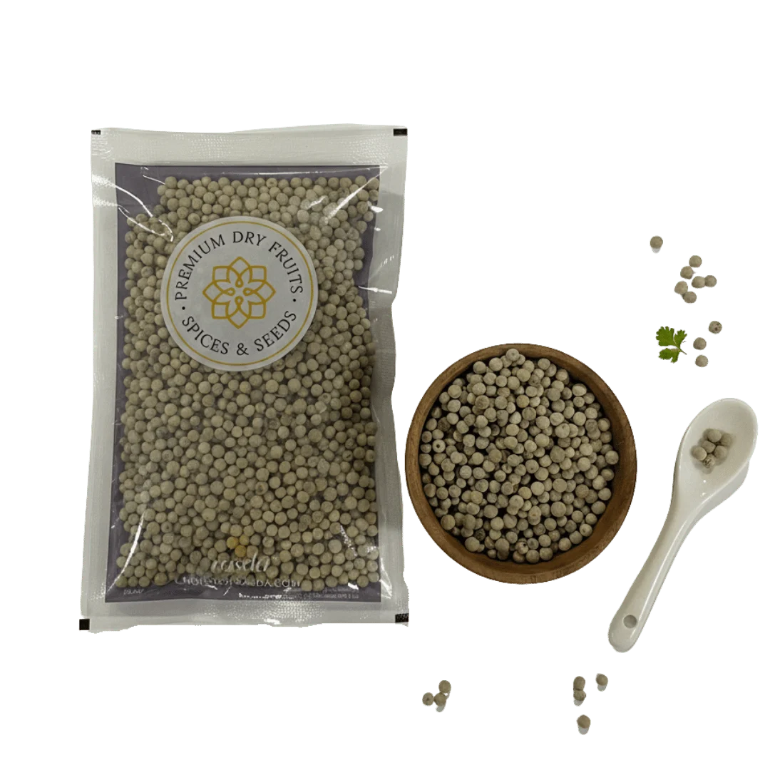 Packaged white peppercorns with a bowl, spoon, and loose peppercorns on a white background.