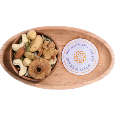 Wooden bowl with Wholesome Nutty Trail Mix assorted dry fruits and spices on a wooden tray.