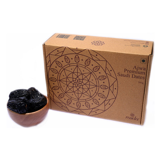 Ajwa dates 500g gift box beside a wooden bowl of the dates on a white background