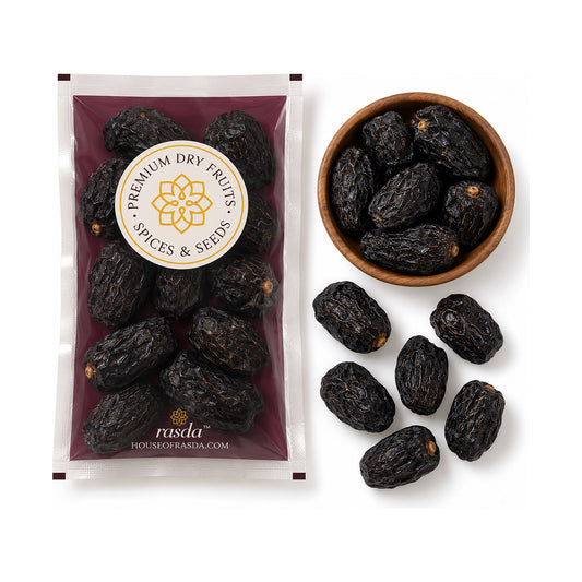 Ajwa dates in a 100g pouch beside a wooden bowl of the dates, with loose dates on a white background