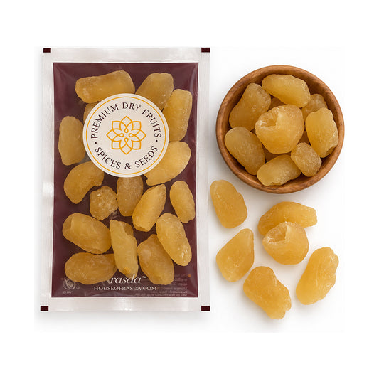 Dried rambutan in a 100g pouch beside a wooden bowl of the fruit, with loose pieces on a white background
